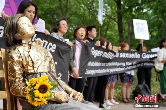 8月14日是国际“慰安妇”纪念日。当天，旅德的韩国和日本民间团体在柏林举行集会，要求日本政府向“慰安妇”制度暴行受害者正式道歉，并作出赔偿。图为当天下午，抗议者在德国柏林的日本驻德大使馆前摆放象征受害者的塑像并表达诉求。中新社记者 彭大伟 摄